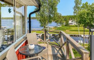 BoxholmにあるBeautiful Home In Boxholm With Kitchenの水辺の景色を望むバルコニー(テーブル、椅子付)
