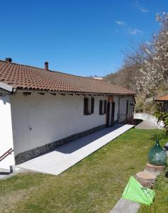 uma casa branca com um quintal ao lado de um edifício em B&B la Casa del daino em Millesimo