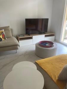 a living room with a flat screen tv and a couch at Escale à Saint-Tropez in Saint-Tropez