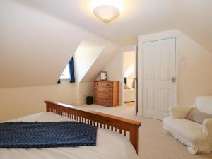 a attic bedroom with a bed and a chair at The Annexe in Petworth