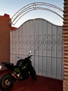 a motorcycle parked in front of a metal gate at Villa privée Wafa in Marrakesh