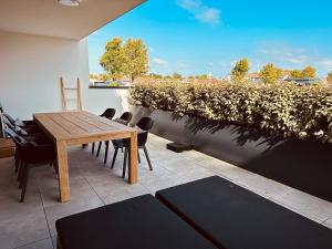 a wooden table and chairs sitting on a patio at Luxe appartement Cadzand-Bad in Cadzand