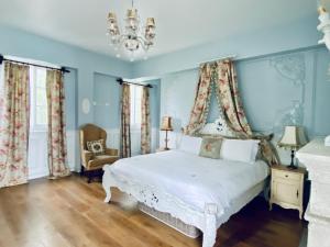 a bedroom with a white bed with blue walls and a chandelier at 法國小古堡- 包棟-Chateau de France in Wujie