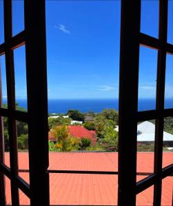 uma vista para o oceano a partir de uma janela em Habitation La Reine du Camp Chambres d'Hôtes em Saint-Claude