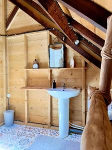 La salle de bains en bois est pourvue d'un lavabo blanc. dans l'établissement Habitation La Reine du Camp Chambres d'Hôtes, à Saint-Claude