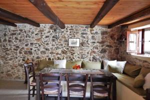 a dining room with a table and a stone wall at Traditional stone house camari in Apóstoloi