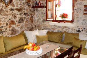 a living room with a couch and a table with a bowl of fruit at Traditional stone house camari in Apóstoloi