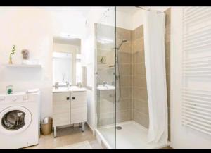 uma casa de banho com um chuveiro e uma máquina de lavar roupa em Appartement Cosy à 8 min Disney 20 min Paris em Montévrain