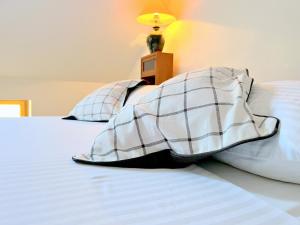 2 almohadas en una cama con lámpara en la parte superior en Casa Vecchia Holiday Home Rab en Rab