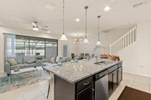 a kitchen with a counter top and a living room at Luxury 5BD/5BH Home With Pool/BBQ Disney Universal in Kissimmee