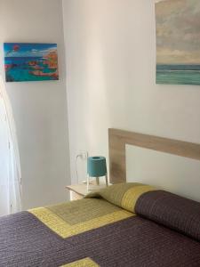 um quarto com uma cama e uma cadeira azul em Hostal Mediterraneo em Torre del Mar