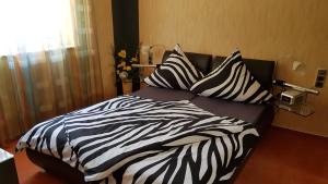 een bed met zwarte en witte lakens en kussens bij ALACARD Ferienwohnungen Höffgen Thale Harz in Thale