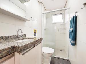 uma casa de banho com um lavatório e um chuveiro. em Apto 3 quartos, sacada, churrasqueira e garagem em Londrina
