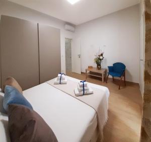 1 dormitorio con 2 camas y silla azul en REGINA ANNA HOME, en Bari