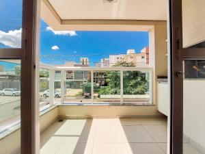 een kamer met een raam met uitzicht op een straat bij Apto 3 quartos, sacada, churrasqueira e garagem in Londrina