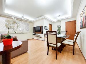 uma sala de estar com uma mesa e um sofá em Apto 2 quartos, centro, garagem, ar condicionado em Londrina