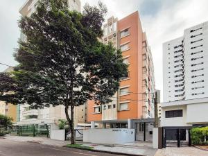 uma árvore em frente a um edifício alto em Apto 2 quartos, centro, garagem, ar condicionado em Londrina