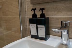 two bottles of soap sitting on top of a sink at B&BSCICCHERI in Castellammare di Stabia