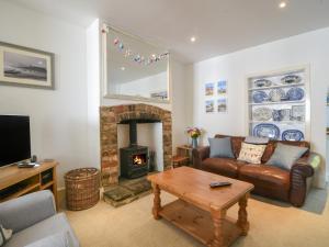 a living room with a couch and a fireplace at 21 Mill Green in Lyme Regis
