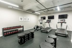 une salle de sport avec des tapis de course et des machines dans une pièce dans l'établissement Kislak 503 Luxurious 2BR Retreat Above the City, à Newark