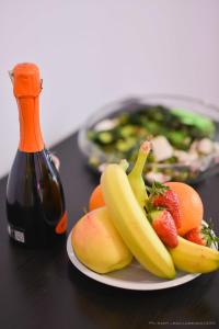 a plate of fruit on a table with a bottle of wine at Magna Cura in Rome