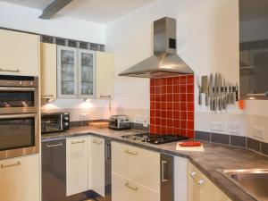 een keuken met witte kasten en een fornuis met oven bij The Old Garage in Lyme Regis