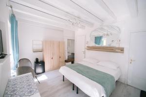 a white bedroom with a bed and a mirror at Casa Cavour Garda in Garda