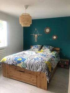 Schlafzimmer mit einem Bett mit blauer Wand in der Unterkunft Maison 3 chambres in Saint-Aunès