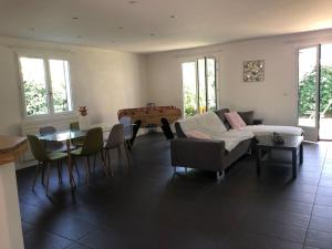 ein Wohnzimmer mit einem Sofa und einem Tisch in der Unterkunft Maison 3 chambres in Saint-Aunès