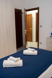 duas toalhas numa cama azul num quarto em B&BSCICCHERI em Castellammare di Stabia
