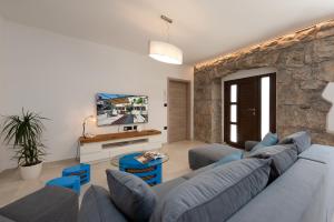 a living room with a blue couch and a stone wall at Casa Fiumana Laura in Rijeka