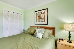 1 dormitorio con cama y mesita de noche con lámpara en Vibrant North Charleston Duplex Near Airport!, en Charleston