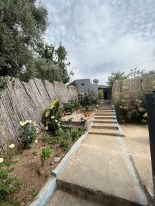 a garden with a wooden fence and a path with flowers at Maison calme et paisible in Beni Mellal