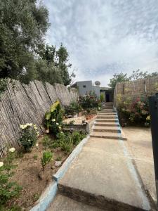 a garden with a fence and a stairway with flowers at Maison calme et paisible in Beni Mellal