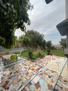 a patio with a table and chairs on a mosaic floor at Maison calme et paisible in Beni Mellal