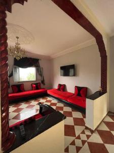 a living room with two beds and a checkered floor at Maison calme et paisible in Beni Mellal