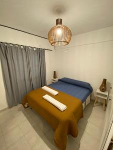 a bedroom with a bed with a blue and yellow blanket at Apartamento Céntrico 5 Personas 3 Ambientes in Santiago del Estero