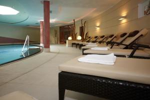 een zwembad met stoelen en een zwembad bij Hotel Carmen in Santa Cristina in Val Gardena