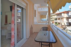 a balcony with a table and a window with a view at Harikleia Studios in Leptokarya