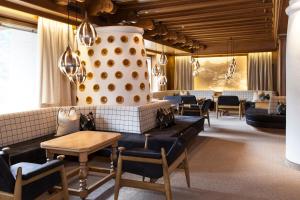 een wachtkamer met banken en een tafel en stoelen bij Hotel Carmen in Santa Cristina in Val Gardena