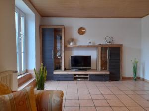 a living room with a flat screen tv on a entertainment center at Haus am Berg in Üdersdorf