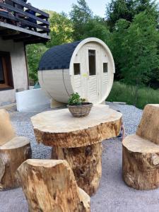 a tree stump table and chairs with a small house at Le chalet du cœur in Mittlach