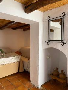Cette chambre comprend un lit et un miroir. dans l'établissement MONTEPERDIDO, à Linares de la Sierra