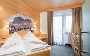 een hotelkamer met een bed en een raam bij Hotel Carmen in Santa Cristina in Val Gardena
