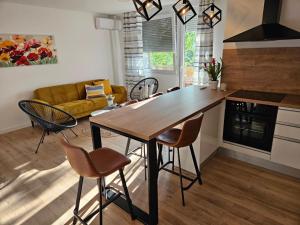 cocina y sala de estar con mesa de madera y sillas en Svalinn en Belišće