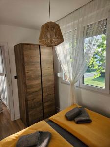 a bedroom with a bed and a window and a chandelier at Svalinn in Belišće