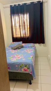 um pequeno quarto com uma cama com flores em Jatiuca 2 em Maceió