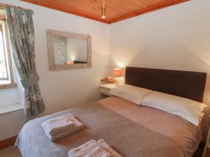 a bedroom with a bed and a mirror and a window at Little Gem in Maryport