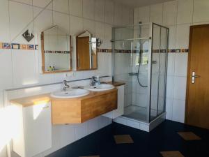 a bathroom with two sinks and a shower at Ferienwohnung Südpfalz mit Fernblick in Böchingen