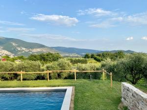 a swimming pool in a yard with mountains in the background at Agriturismo Ca' Cristane in Rivoli Veronese